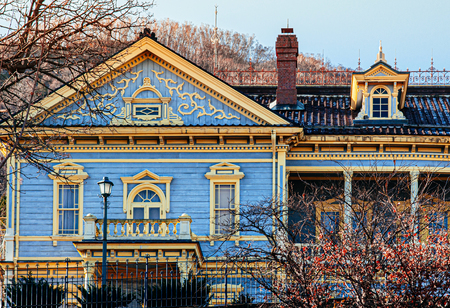 DEC 2, 2018 Hakodate, JAPAN - Colourful Old Hakodate Public Hall European style building among big trees in Motomachi with Mount Hakodate in background in autumn season.のeditorial素材
