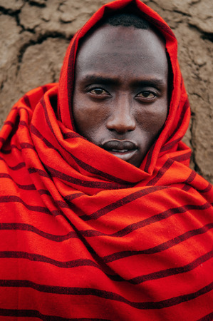 JUN 24, 2011 Serengeti, Tanzania - Portrait of African Masai or Maasai tribe man in red cloth eyes staring at camera. Clearly face detail wrinkle and skin. Ethnic group of Ngorongoro Consevation, Serengeti Savanna forest.のeditorial素材