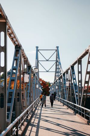 NOV 18, 2014 Okayama, Japan - Local Japanese tourists walking on old Iron bridge crossing Asahi river at Okayama castleのeditorial素材