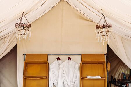 JUN 22, 2011 Serengeti, Tanzania - Luxury Safari tent camp interior bathrobe in Serengeti Savanna forest Grumeti reserve game drive area  - Glamping travel in Africa wild forestのeditorial素材