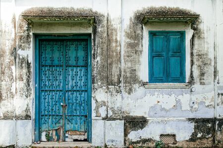 Old blue iron door and window of colonial vintage grungy abandoned house in Havana, Cubaの写真素材