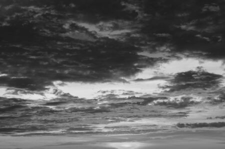 Black and white summer burning sunset or sunrise sky with scattered cloudsの写真素材