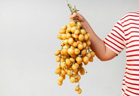 Yellow beautiful bunch of Ma Fai - Som Fai or Burmese Grape southeast asian tropical wild fruit in...
