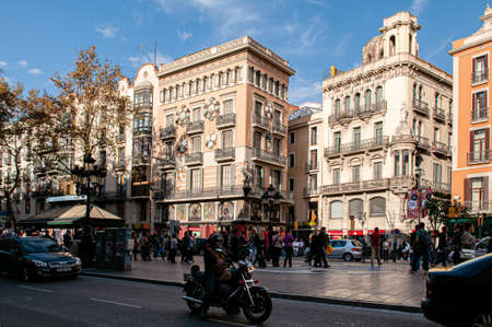 OCT 27, 2012 Bearcelona, Spain - Old Classic buildings and traffic on La Rambla street under warm...