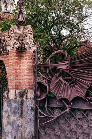OCT 26, 2012 Barcelona, Spain - Red brick ornate vintage wall and iron dragon gate of Pavilion Guell, Ruins of a grand complex  of Count GÃ¼ell.のeditorial素材