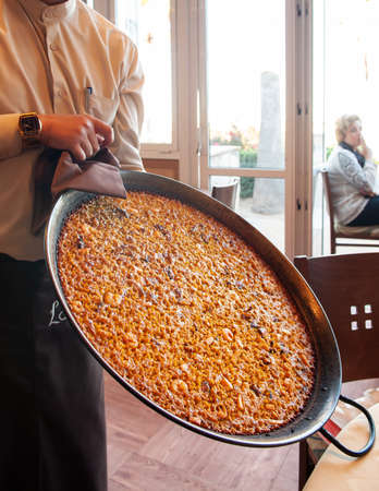 OCT 28, 2012 Valencia, Spain - Hot Paella Spanish seafood fried rice in large iron pan serving in La Marcelina famous restaurant in Valencia.のeditorial素材