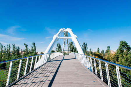 Valencia, Spain - White suspension bridge in Valencia Bioparc under blue sky in autumn