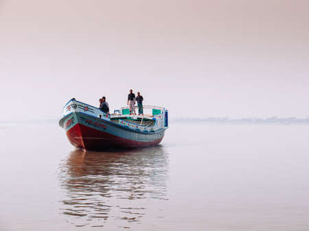 FEB 15, 2012 Dhaka, Bangladesh - Bangladesh local people packed on wooden boat in peaceful river in...