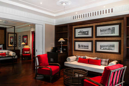 MAR 5, 2012 Chiang Mai, Thailand - Red armchairs and couch seat in Asian comtemporary living area in resort style bedroom with oriental decorationのeditorial素材