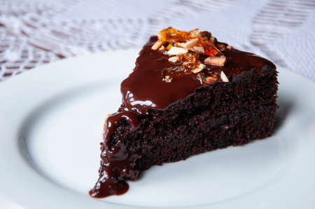 Rich glazed chocolate fudge cake with roasted almond and sugar glass flakesの写真素材