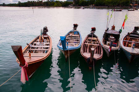 Colorful longtail fishing boat in small canal during monsoon season in Phuketの写真素材