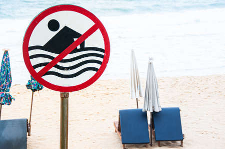 No swimming sign with beach view strong wave and beach beds in Monsoon seasonの写真素材