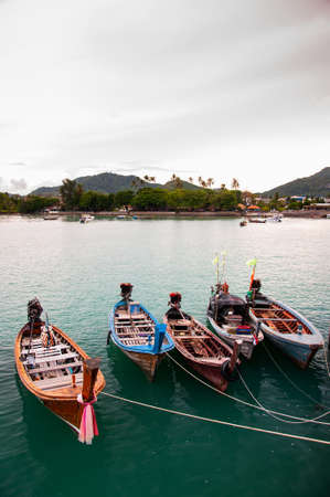Colorful longtail fishing boat in small canal during monsoon season in Phuketの写真素材