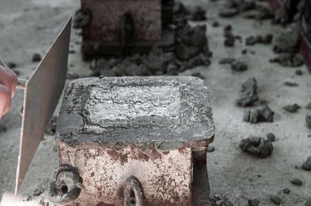 Pouring Concrete mix in mold making concrete cube for strength testingの写真素材