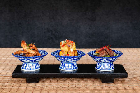 Thai fried snack fried tofu fried pork in ceramic bowls with dark backgroundの写真素材