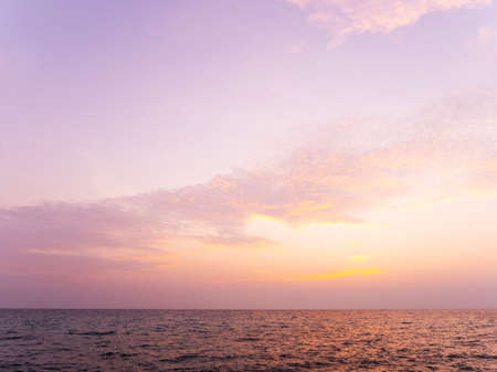Peaceful serene sea scape and golden purple tone sunset or sunrise sky with clouds, tropical island...
