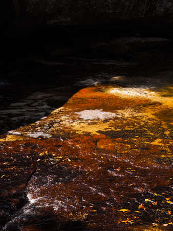Rough dark grainy natural red brown sand stone texture background with scratches and uneven surfaceの写真素材