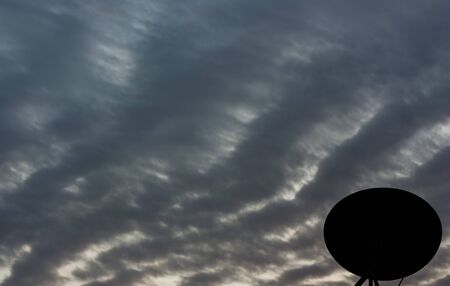 Silhouette satellite dish with a colorful skyの写真素材