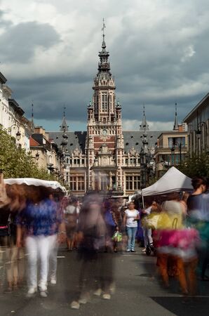 Long exposure photo of a street market with the the Town hall of Shaerbeek in Brussels, Belgium in the backgroundの写真素材