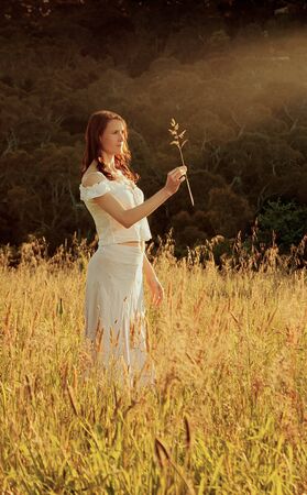 Woman alone in nature appreciating the plantsの写真素材