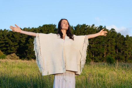 Young woman with her arms raised enjoying natureの写真素材