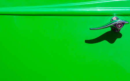 Car door handle on a green door.の写真素材
