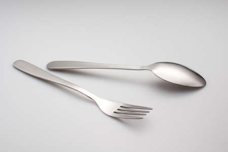 a silver fork with spoon isolated on gray background