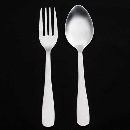 a silver fork with spoon isolated on black backgroundの写真素材