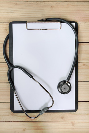 clipboard with stethoscope and syringe on wooden backgroundの写真素材