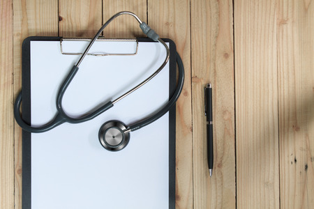 clipboard with stethoscope and syringe on wooden backgroundの写真素材