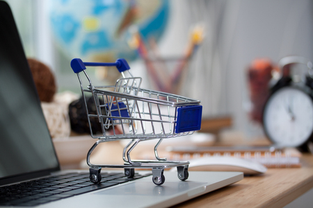 Mini shopping cart on computer laptop. Business concept.の写真素材