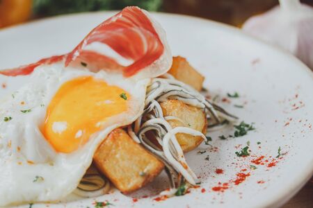 Ham with egg fried and potato deep fried. Spanish breakfast cuisine.の写真素材