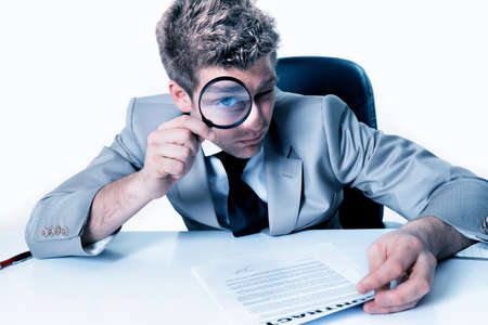 Businessman with magnifying glass study contractの写真素材
