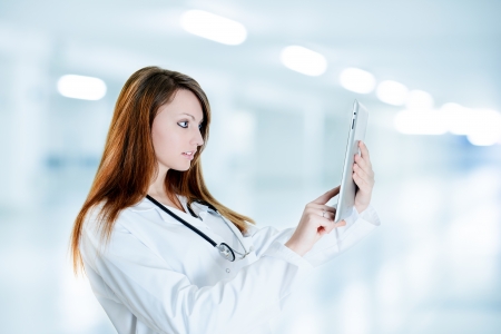 Nurse Using Digital Tablet and wearing a lab coat at hospitalの写真素材