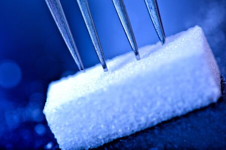 close up of sugar cubes with a fork planted over