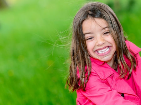 Portrait of little happy cute girl drinking water in a fountainの写真素材
