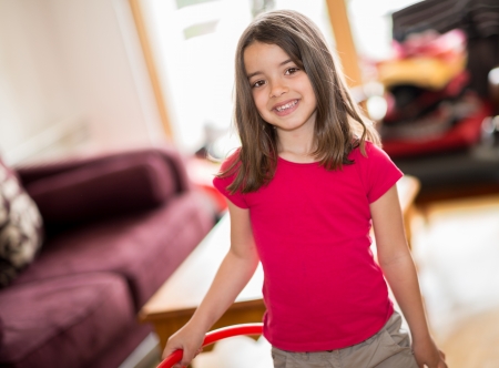 happy cute child with a hoop in the hands standing in a living roomの写真素材
