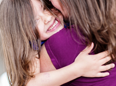 Expressive portrait of pretty girl hugging her motherの写真素材