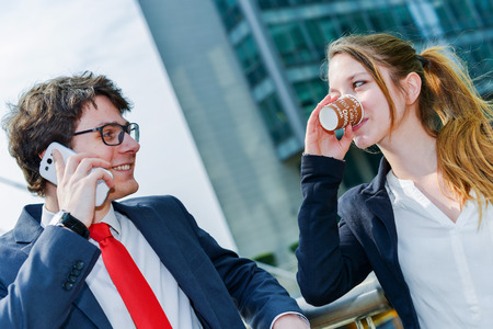 Junior executives having a coffee break in front of their companyの写真素材