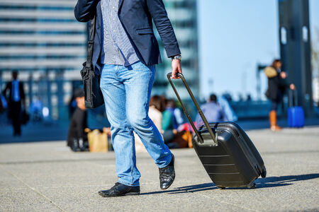 front view of traveler man walking with suitcase in the streetの写真素材