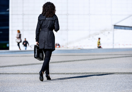 Back view of Young business woman walking on the city streetの写真素材