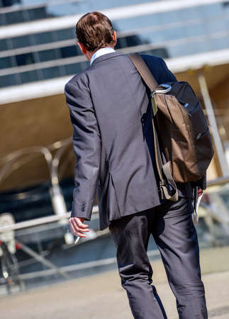 Back view of Business traveler man walking with suitcase in the streetの写真素材