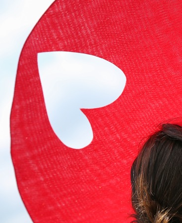 Elegant woman with her beautiful red heart hat at the Prix de Diane, Franceの写真素材