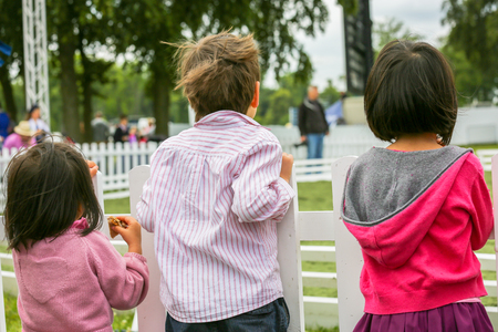 View of three lovely children watching a showの写真素材