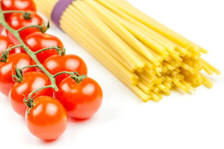 Spaghetti and tomatoes with herbs on an old and vintage wooden tableの写真素材