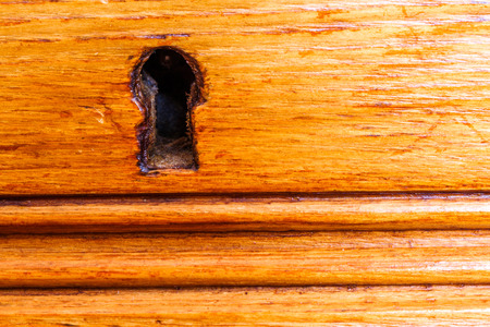 closeup on keyhole of luxurious wooden cabinetの写真素材