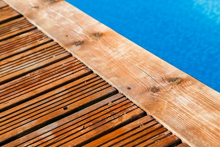 close up on swimming pool with treated wood damaged