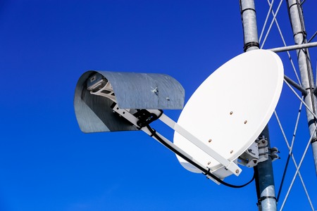 parabolic antenna off white against the blue skyの写真素材