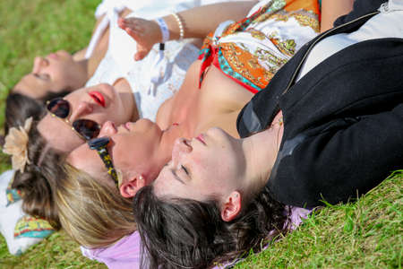 CHANTILLY - JUNE 15: Pretty girls group lying on the grass at the Prix de Diane - The Prix de Diane horse race is a French who runs Every year in June. In an atmosphere of sporting fervor and chic picnic Chantilly. Considered the price of elegance and disのeditorial素材