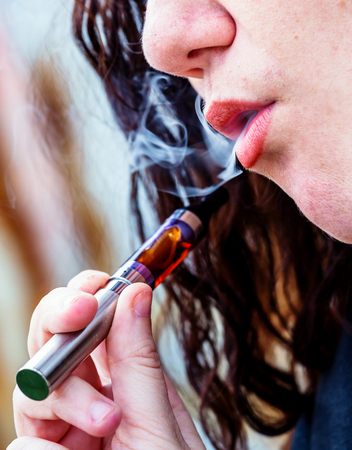 Close up of a woman inhaling from an electronic cigaretteの写真素材